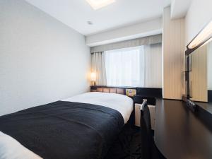 een hotelkamer met een bed en een raam bij APA Hotel Nishifunabashi Ekimae in Nakayama