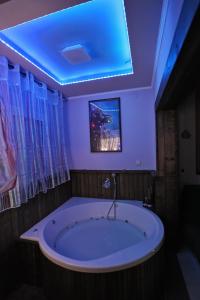 a large tub in a bathroom with a blue ceiling at Passion Fruit Apartment in Ashkelon