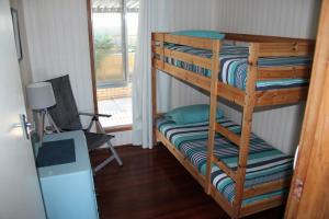 a bunk bed in a room with a window at The Beach Shack - OCEAN VIEWS, CLOSE TO THE BEACH in Guilderton