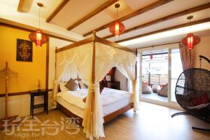 um quarto com uma cama de dossel e uma varanda em Park 61 em Luodong