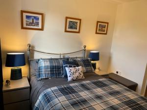 ein Schlafzimmer mit einem Bett mit Kissen und zwei Lampen in der Unterkunft Luxury Portrush Holiday Homes - The Grange, Portrush Sleeps 13 - 6 bedrooms in Portrush