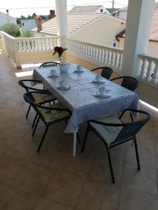 a blue table with chairs and a vase on it at Apartments Kampor (4235) in Kampor