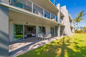 a house with a patio with a table and chairs at Marina Park Apartments Whitianga in Whitianga