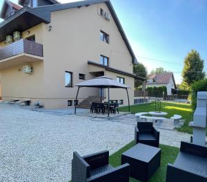 a patio with chairs and an umbrella in front of a building at CITY Apartman in Balatonföldvár