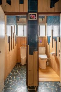 a bathroom with a toilet and a urinal at Guesthouse EN in Rusutsu
