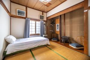 a bedroom with a bed and a window at Guesthouse EN in Rusutsu