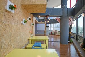 a room with a yellow table and chairs in a building at Dashim Guest House in Gunsan