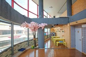 a room with a table and a tree with pink flowers at Dashim Guest House in Gunsan-si