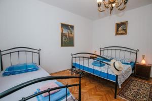 a bedroom with two beds and a chandelier at Apartman Bagattino-Trogir near Old Town in Trogir