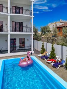 a woman in an inflatablevisor in the swimming pool of a hotel at Villa Bonapart in Zatoka