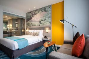 ジャカルタにあるメルキュール ジャカルタ チキニのベッドとソファ付きのホテルルーム