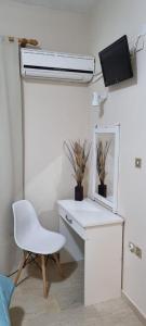 białe biurko z krzesłem i telewizor na ścianie w obiekcie IONIAN MARE w mieście Agios Ioannis Peristerion