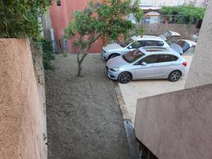 dos autos plateados estacionados junto a un árbol en Appartement avec parking privatif à Collioure, en Collioure