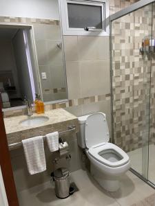 y baño con aseo, lavabo y ducha. en Asuncion Gracia Suites en Asunción