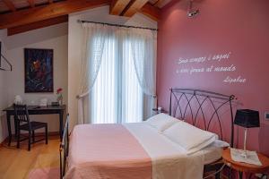 um quarto com uma cama, uma secretária e uma janela em Rosa del Grappa em Rosà