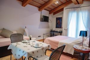 1 dormitorio con 1 cama, mesa y sillas en Rosa del Grappa, en Rosà