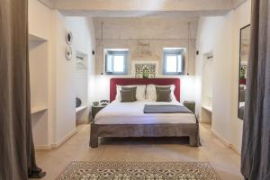 a bedroom with a large bed with a red headboard at Borgo dei Lecci Puglia in Selva di Fasano
