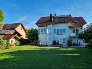 une maison avec une grande cour avec de l'herbe verte dans l'établissement Haus Sonnengarten, à Kapellen-Drusweiler