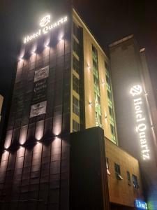 um edifício de hotel com uma placa à noite em Hotel Quatz em Busan