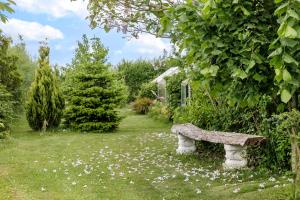 a stone bench in the middle of a garden at Conedue B&B in Væggerløse
