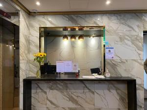 una hall con specchio e bancone con fiori di Hotel Quatz a Busan