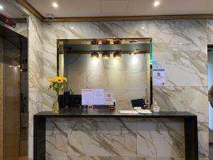 a lobby with a mirror and a counter with flowers at Hotel Quatz in Busan