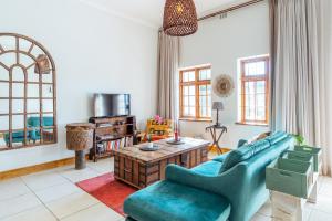 a living room with a blue couch and a table at Spacious Gem, Outdoor Space, Close to TBMTN&City in Cape Town