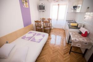 Pokój z łóżkiem i stołem oraz kuchnią w obiekcie Apartments Lopar 178 w mieście Lopar
