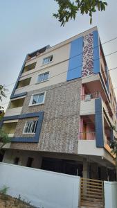 a tall building with blue windows and stairs on it at Tirupati Homestay - 2BHK AC Family Apartments near Alipiri and Kapilatheertham - Walk to A2B Veg Restaurant - WiFi - Android TV - Easy access to Tirumala in Tirupati