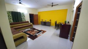 a living room with a couch and a table at Tirupati Homestay - 2BHK AC Family Apartments near Alipiri and Kapilatheertham - Walk to A2B Veg Restaurant - Super fast WiFi - Android TV - 250 Jio Channels - Easy access to Tirumala in Tirupati