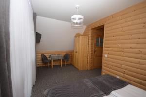 a bedroom with a bed and a table and chairs at uDany in Brzegi