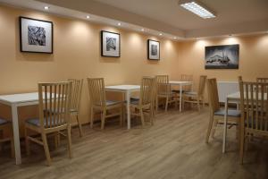 a restaurant with tables and chairs and pictures on the wall at Pokoje Gościnne w WSE in Białystok