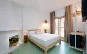 a bedroom with a white bed and a fireplace at Hostal Boutique Cana Rita in San Antonio