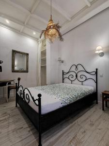 a bedroom with a black bed and a chandelier at Jardin Vieux Port Panier in Marseille