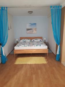 1 dormitorio con 1 cama con cortinas azules en Komfortzimmer Haus Dervaritz, en Einöd