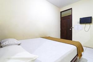 Un pat sau paturi într-o cameră la Guest House Taman Sari Syariah