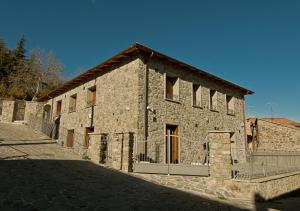 un edificio de piedra con una puerta delante en PaeseMio Cervarezza, en Cervarezza