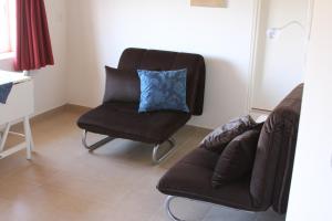 ein Wohnzimmer mit einem Sofa und einem Stuhl in der Unterkunft Peled House of Art in Mevasseret Zion