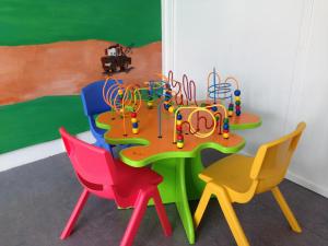 uma mesa com cadeiras coloridas e um conjunto de jogos em Jelling Family Camping & Cottages em Jelling