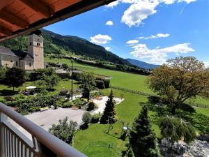 een uitzicht vanaf het balkon van een resort met een park bij Hotel Berghof in Millstatt