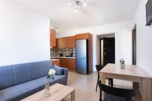 a living room with a blue couch and a table at Tulipa Suites in Yéfira