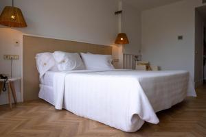 a bedroom with a large bed with white sheets and pillows at Hotel MC San José in San José