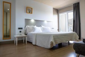 a hotel room with a large bed and a window at Hotel MC San José in San José