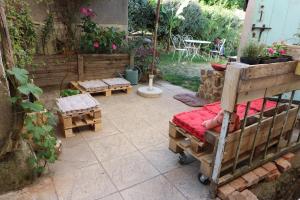 a patio with a bed and benches in a yard at Maison du Lys en Layon in Les Cerqueux-sous-Passavant