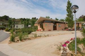 un bâtiment avec une lumière de rue et des fleurs devant lui dans l'établissement Càmping Terra Alta, à Bot