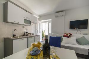 a kitchen and living room with a table and a couch at Apartment Filomena in the center in Komiža