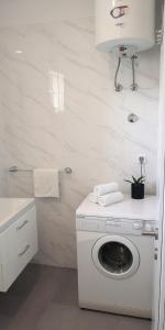 a white laundry room with a washing machine in it at Island Cottage Apartment in Božava