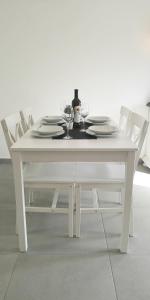 a white table with plates and wine glasses on it at Island Cottage Apartment in Božava