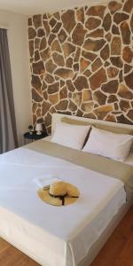 a hat on a bed with a stone wall at Island Cottage Apartment in Božava