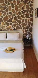 a hotel room with a bed with a hat on it at Island Cottage Apartment in Božava